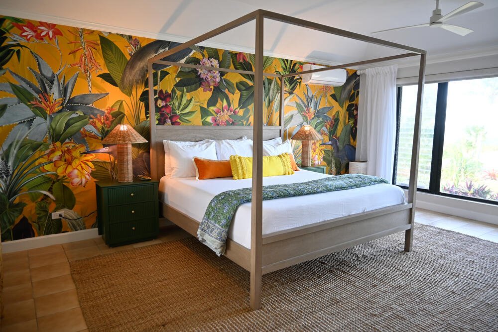 Four-poster bed with tropical wallpaper